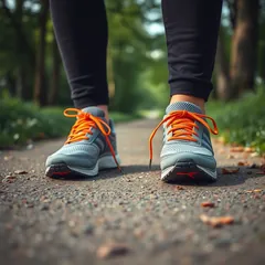 A pair of orange and grey running shoes on a path